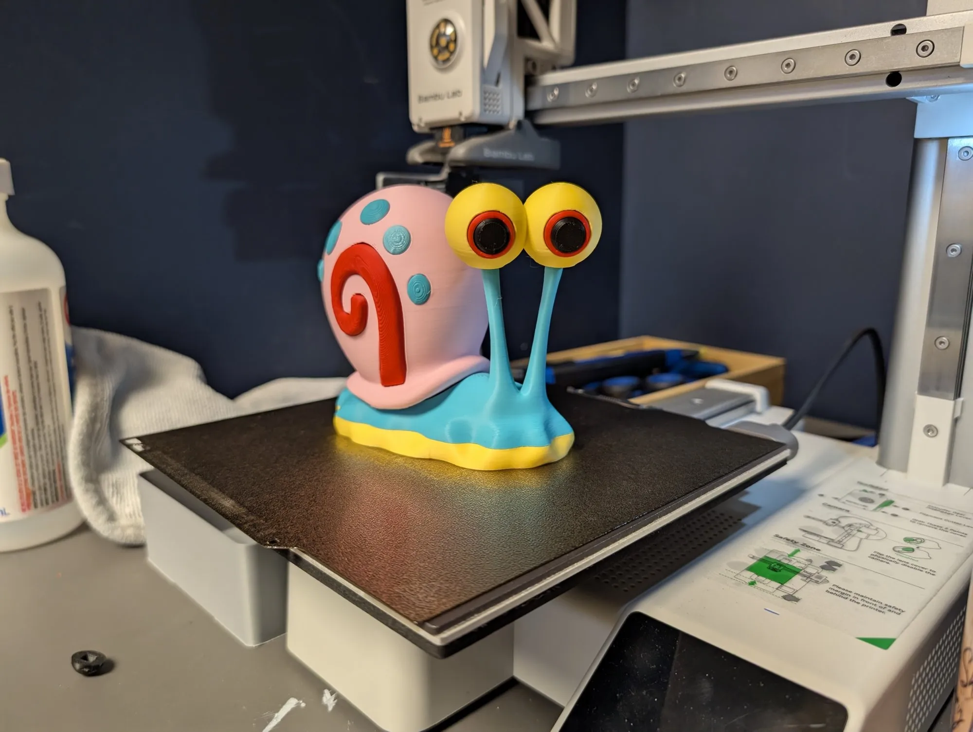 A colourful cartoon snail print on the printer bed